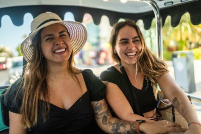 Two smiling woman tourists in golf cart tour.