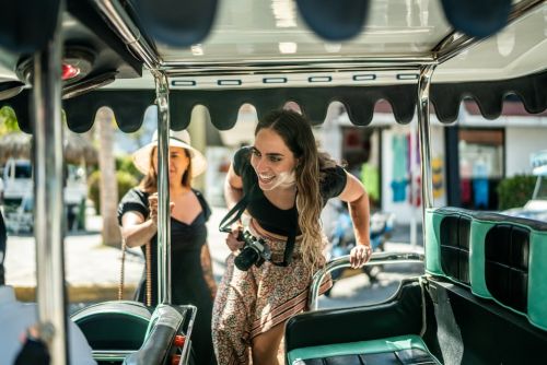 Female traveler friends entering a local taxi